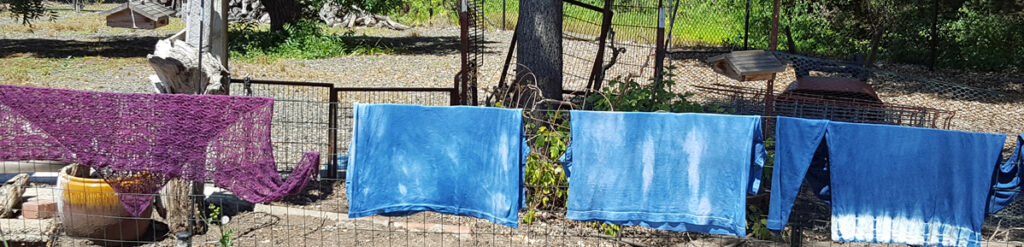 indigo dyed garments hanging on the fence